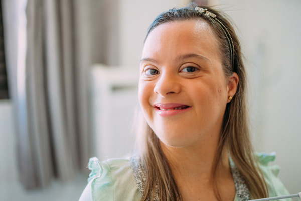 Close up portrait of smiling woman with down syndrome at Special Care Dentistry of Oregon in Albany, OR